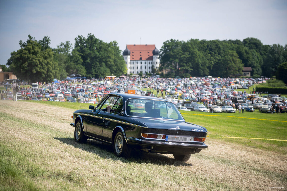 Oldtimer auf Wiese beim Oldie Feeling mit Schloss Maxlrain im Hintergrund